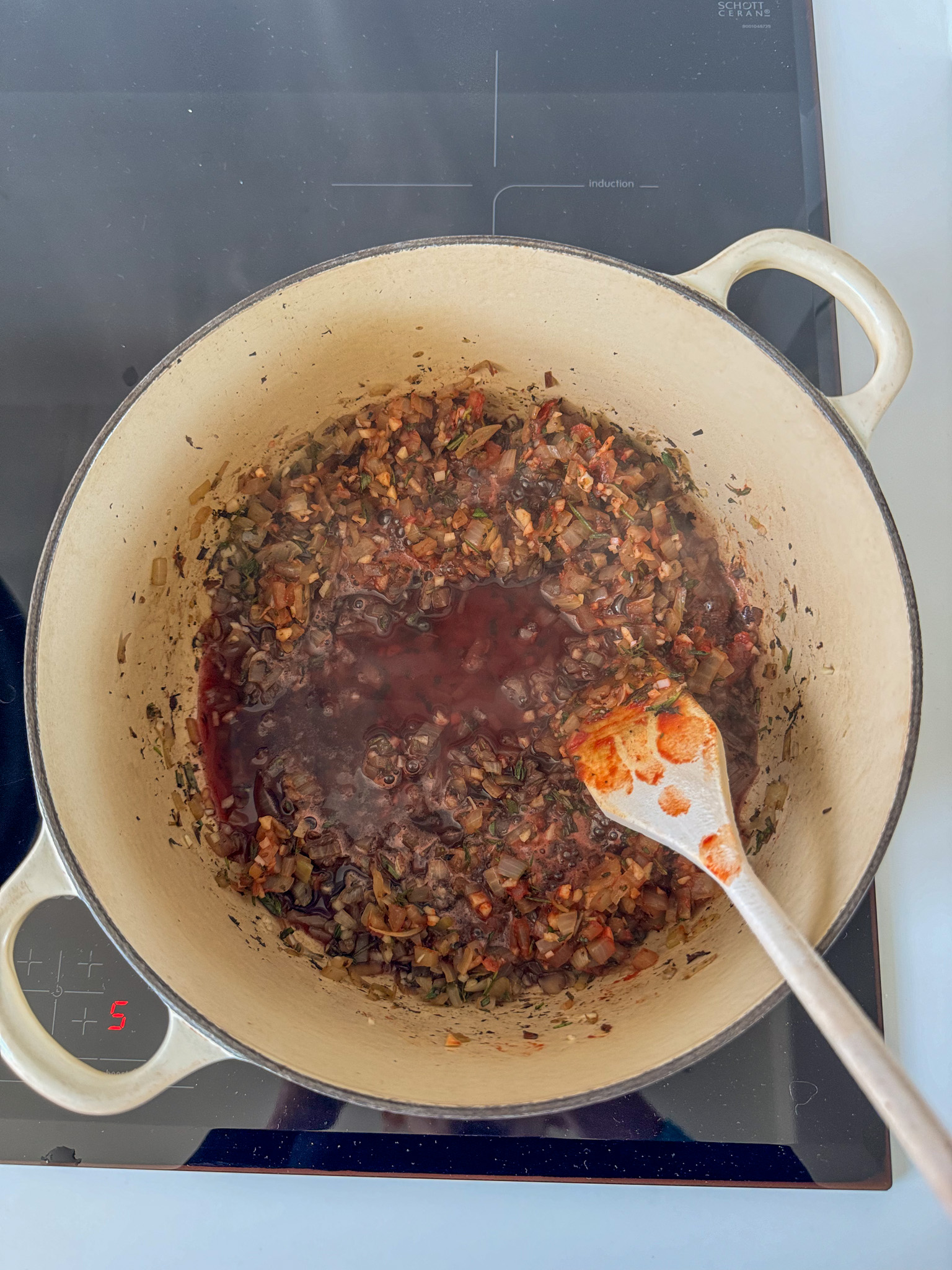 Cooked onions, garlic, herbs being deglazed by red wine