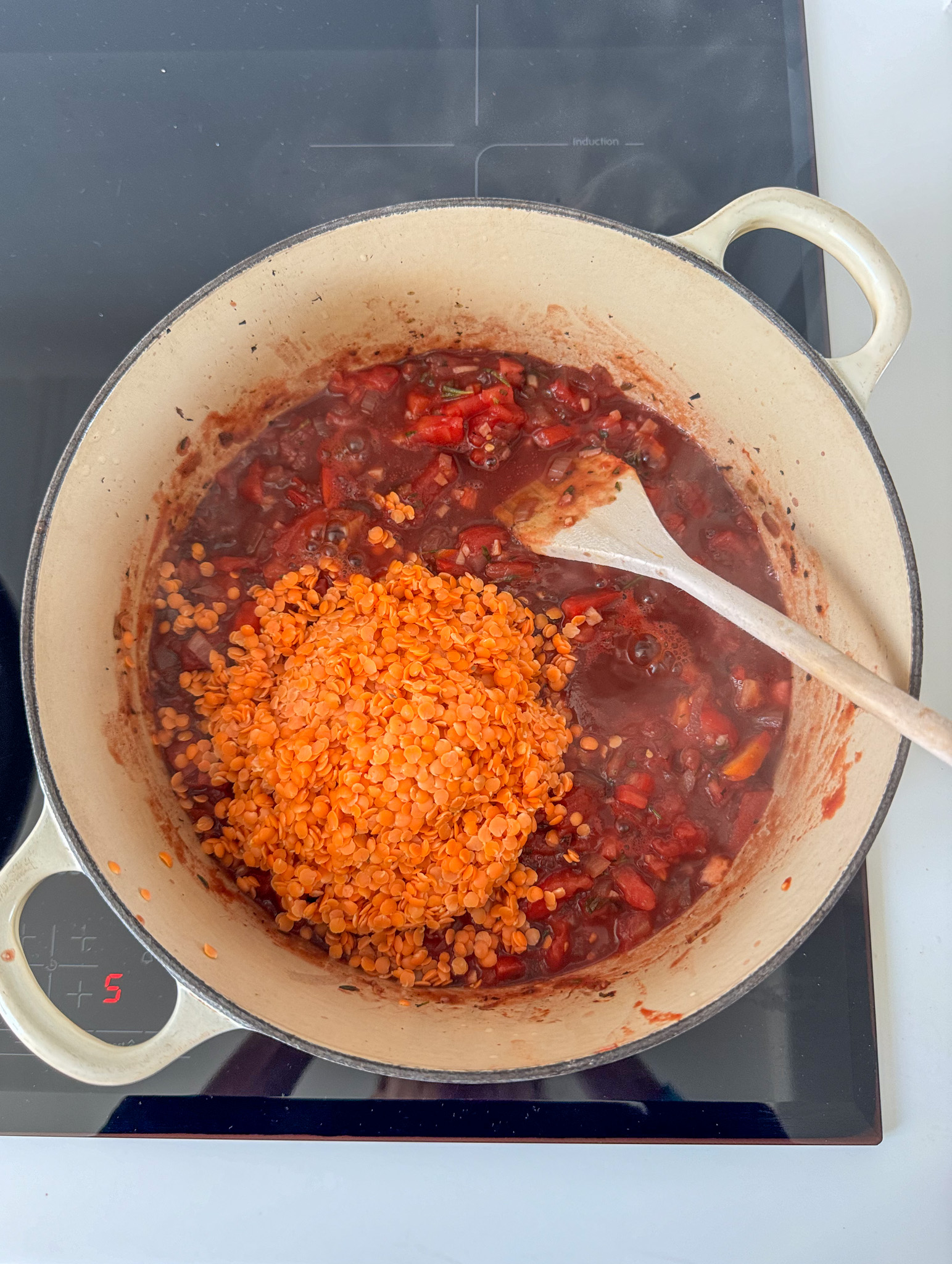 Onions, garlic, tomato and red lentils in a pot