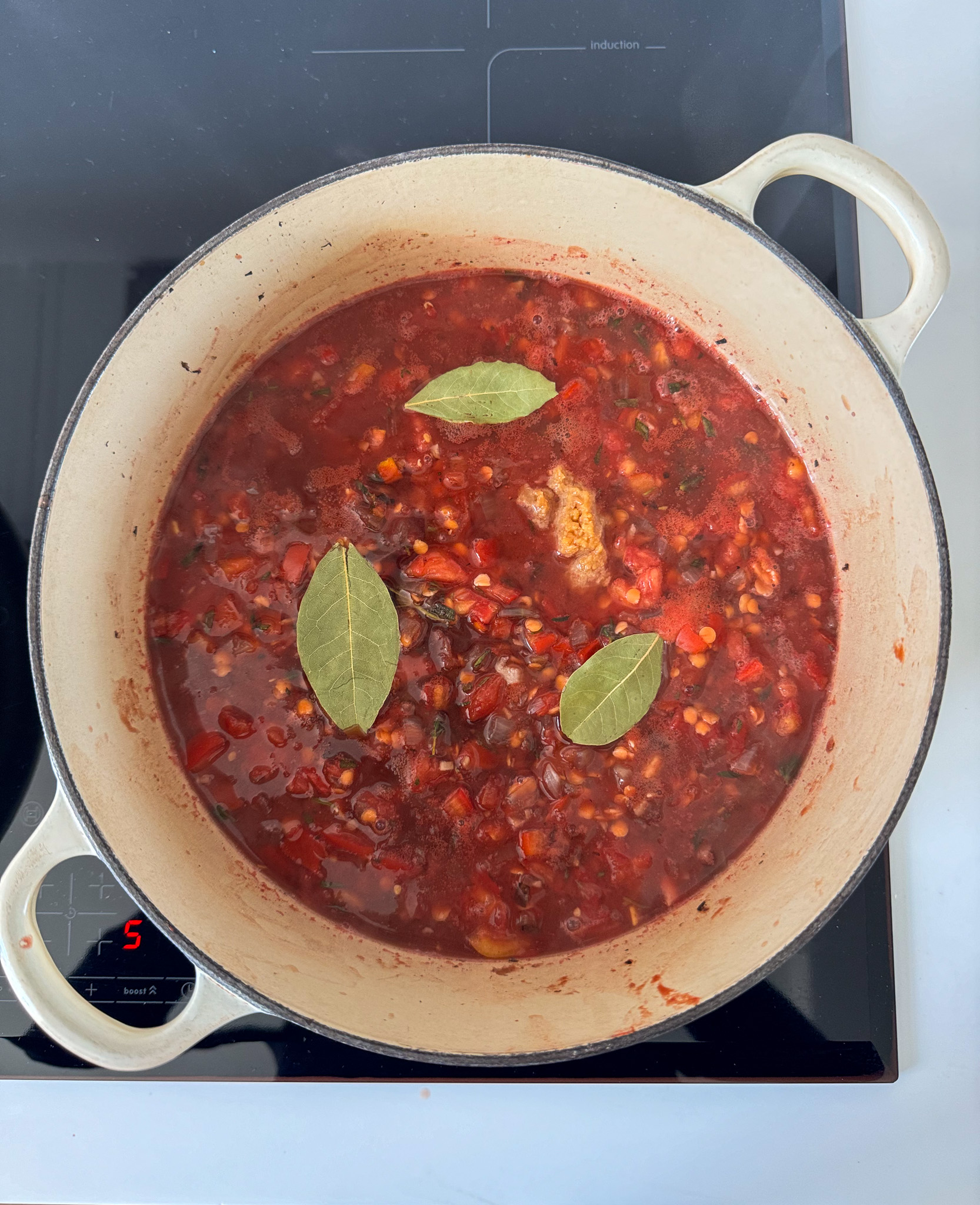 Tomato, Lentils topped with Bay Leaves inside a pot