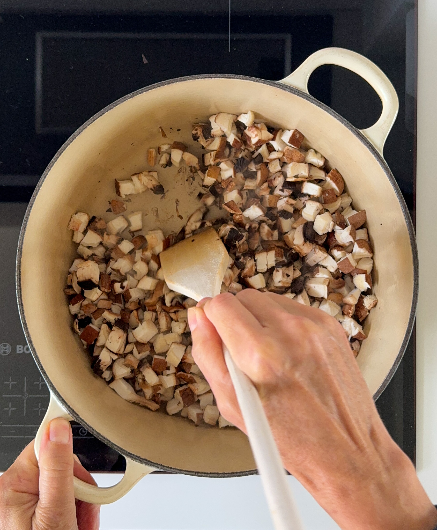 Chopped mushrooms cooking in a Dutch pot