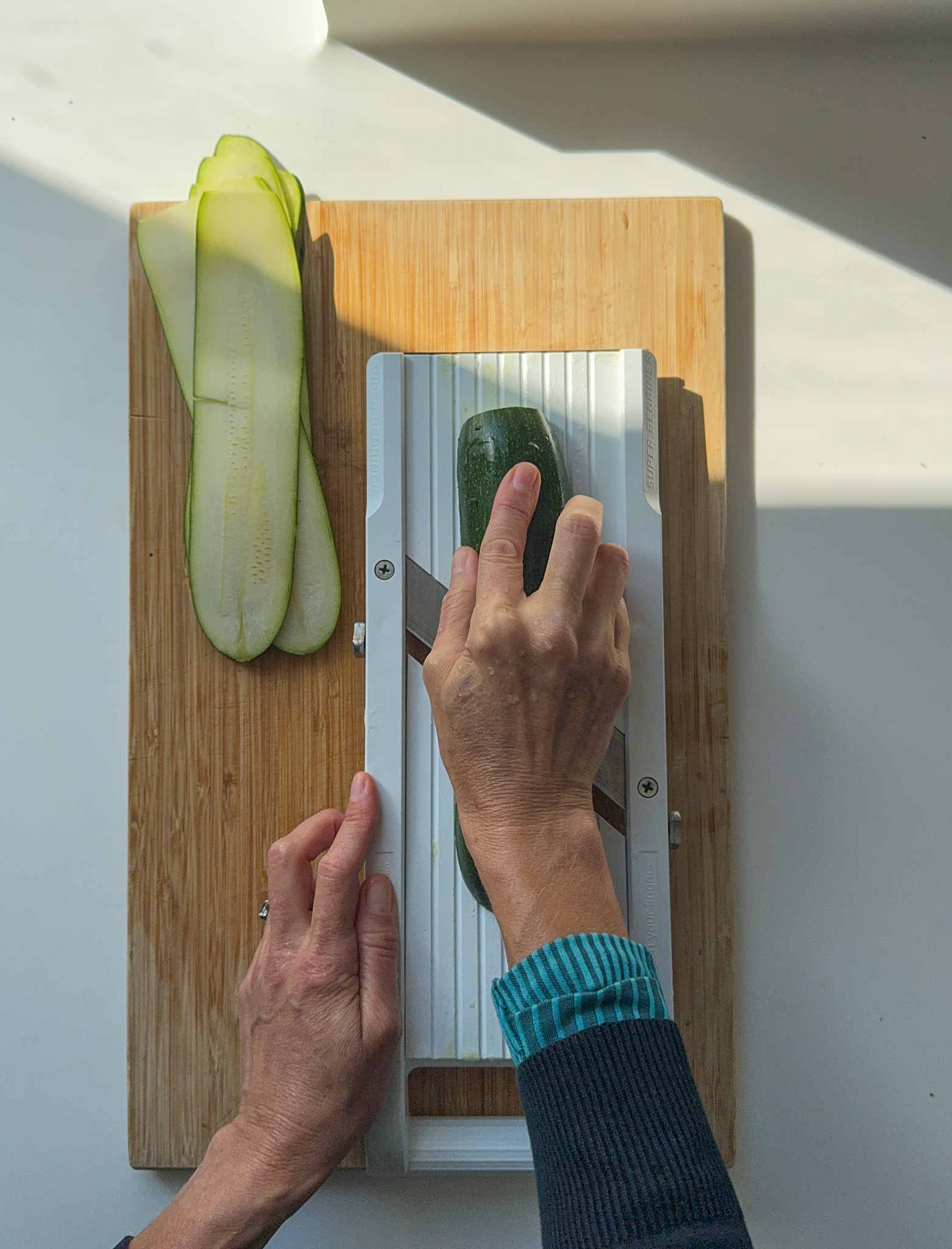 Slicing courgette on a mandolin