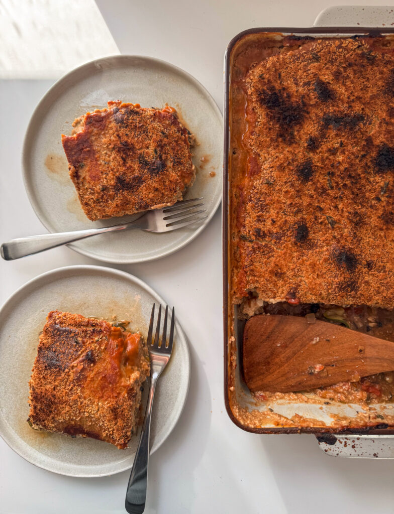 A trey of vegan Lasagne with two planes on the left with 2 squares of lasagne