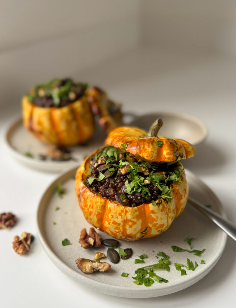 2 roasted pumpkins, stuffed with smoked beluga lentils in 2 small plates springle with parsley