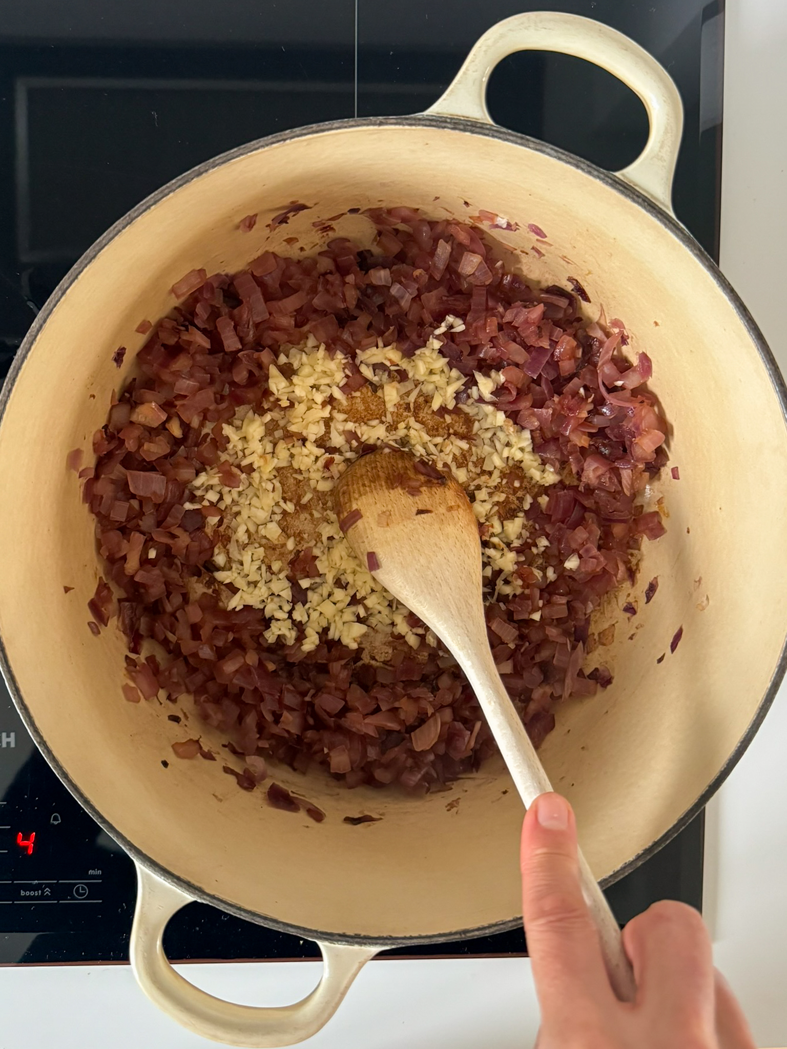 cooked red onion and chopped Garlic on a white dutch oven