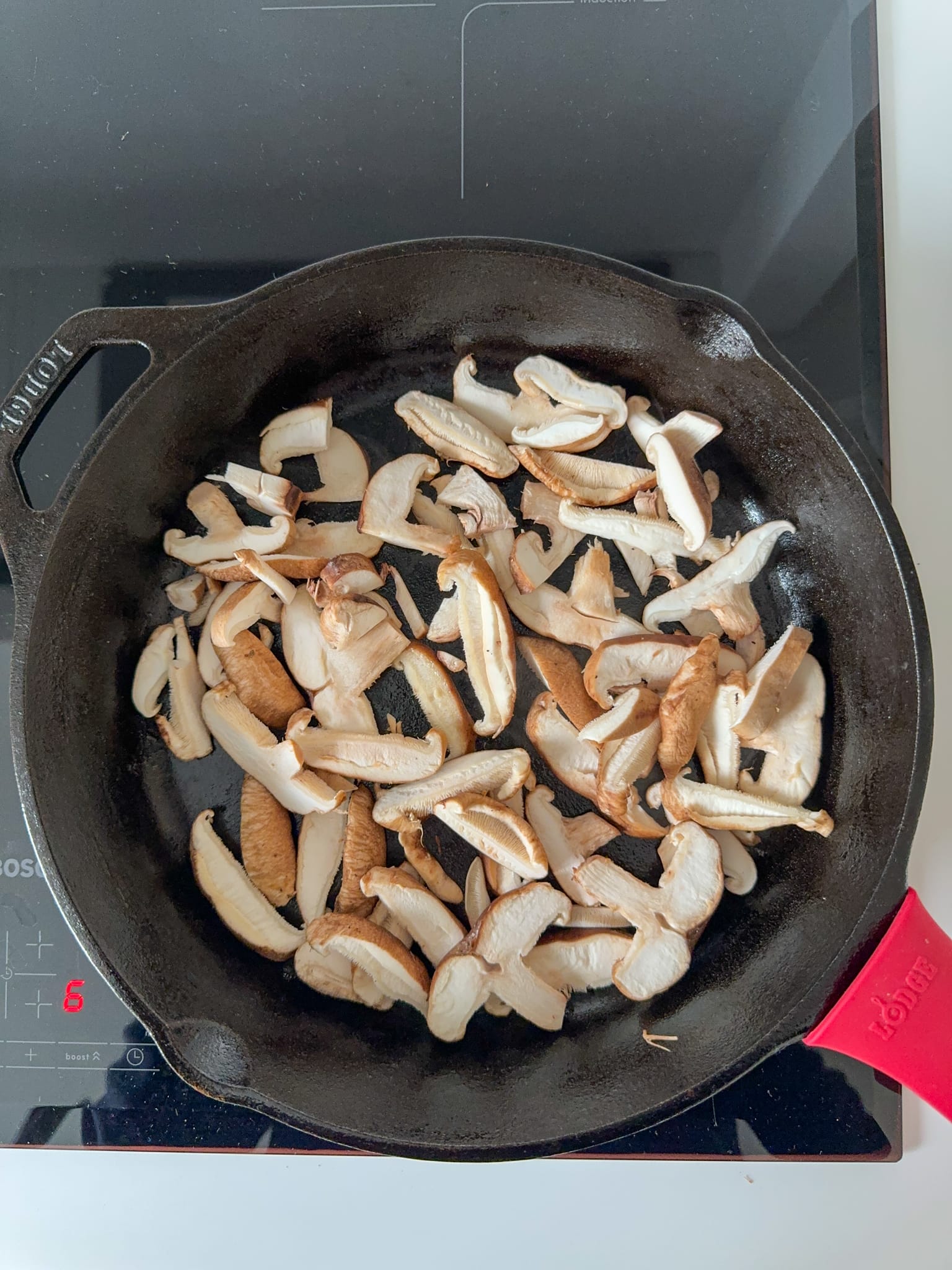 Slice Shiitake Mushrooms on a cast iron pan