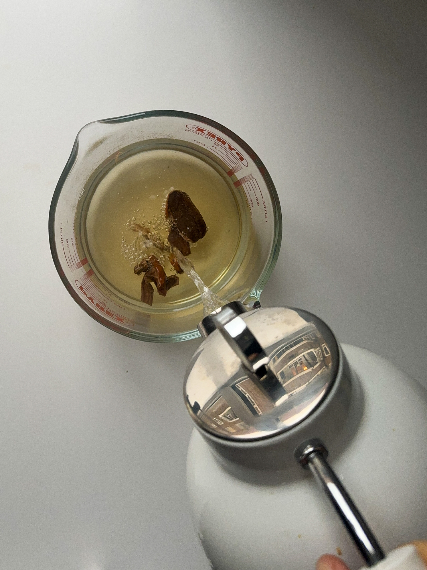 Pouring boiling water into a jar with dry Porcini Mushrooms