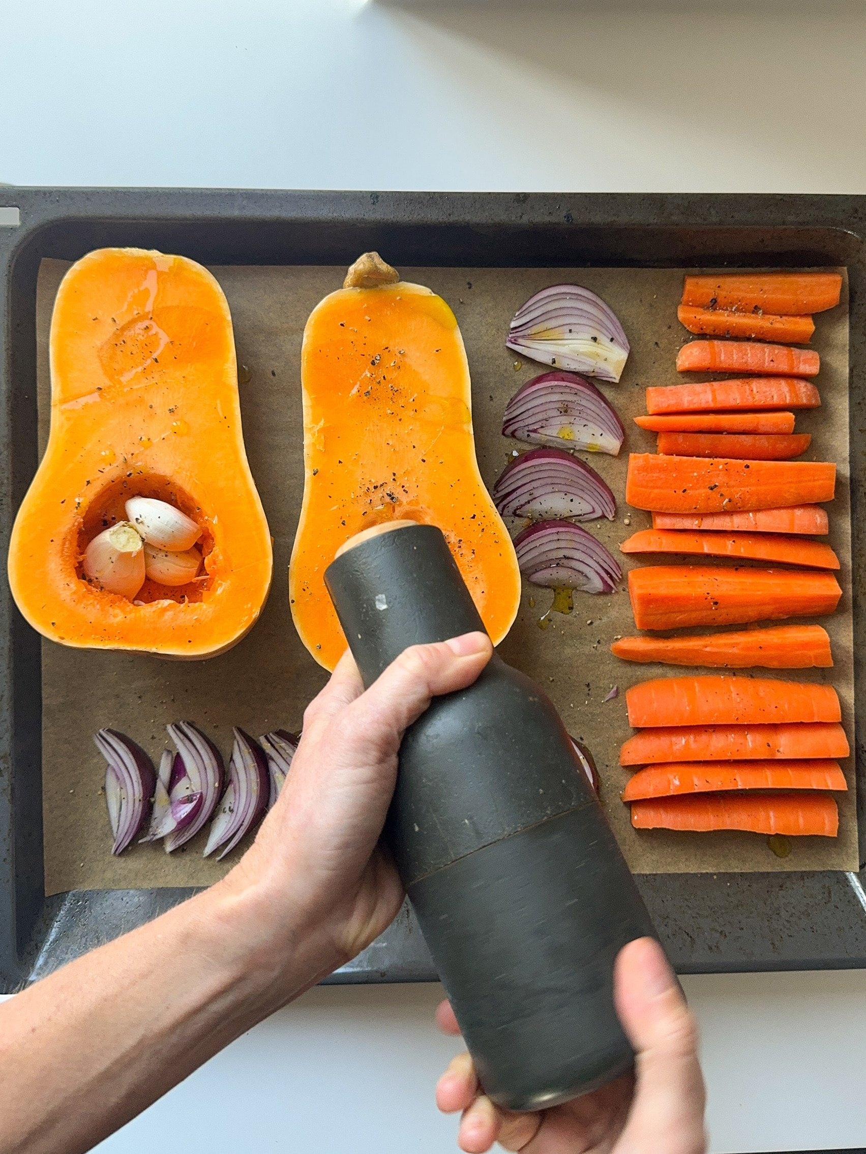 Butternut Squash, carrots, garlic and red onion on a oven tray