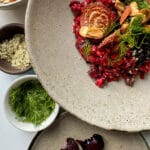 Creamy Roasted beetroot risotto in a bowl , garnish with dill, nuts and almonds