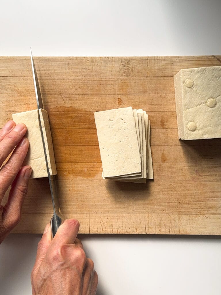 A block of tofu being sliced