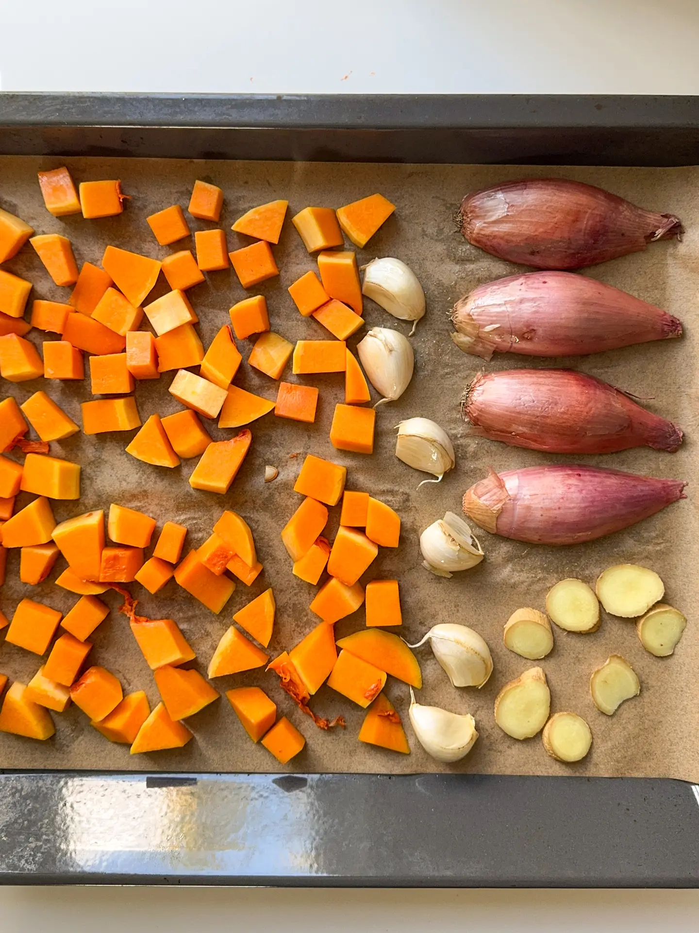 Butternut squash, shallots, garlic and ginger on a oven tray